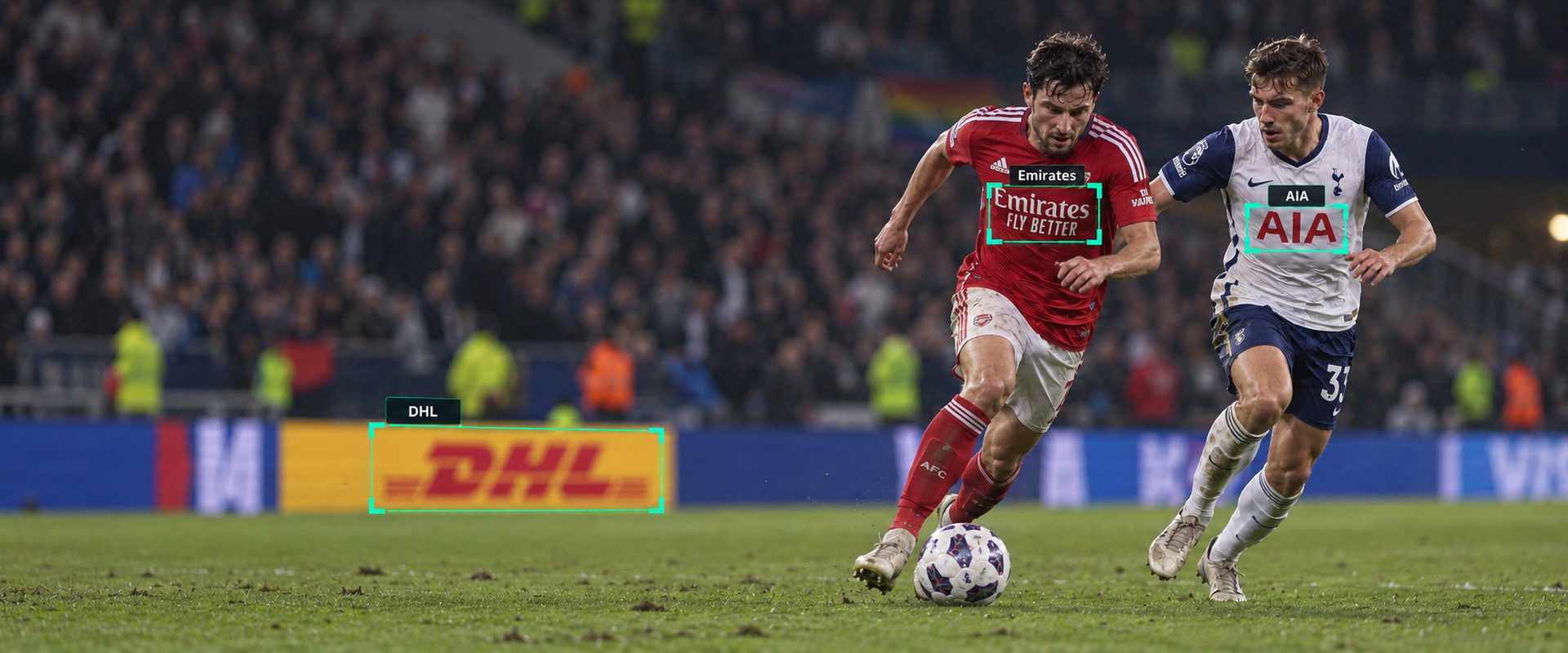 Two footballers contest the ball, with brand detection boxes picked out on the shirt sponsors and the pitch-side signage